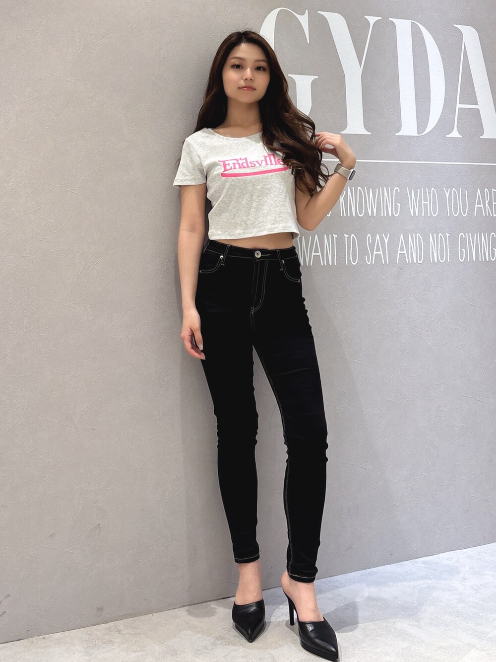 グレー系のTシャツ/カットソー、ブラック系のデニムパンツ、ホワイト系のパンプスを着用したレディースの春コーディネートの2枚目の写真