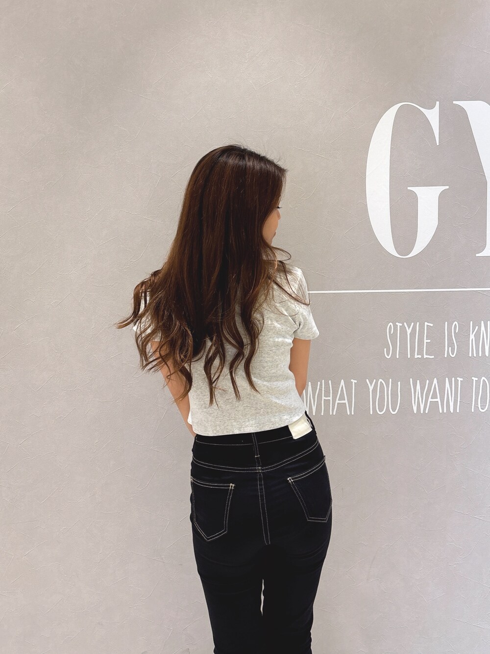 グレー系のTシャツ/カットソー、ブラック系のデニムパンツ、ホワイト系のパンプスを着用したレディースの春コーディネートの7枚目の写真