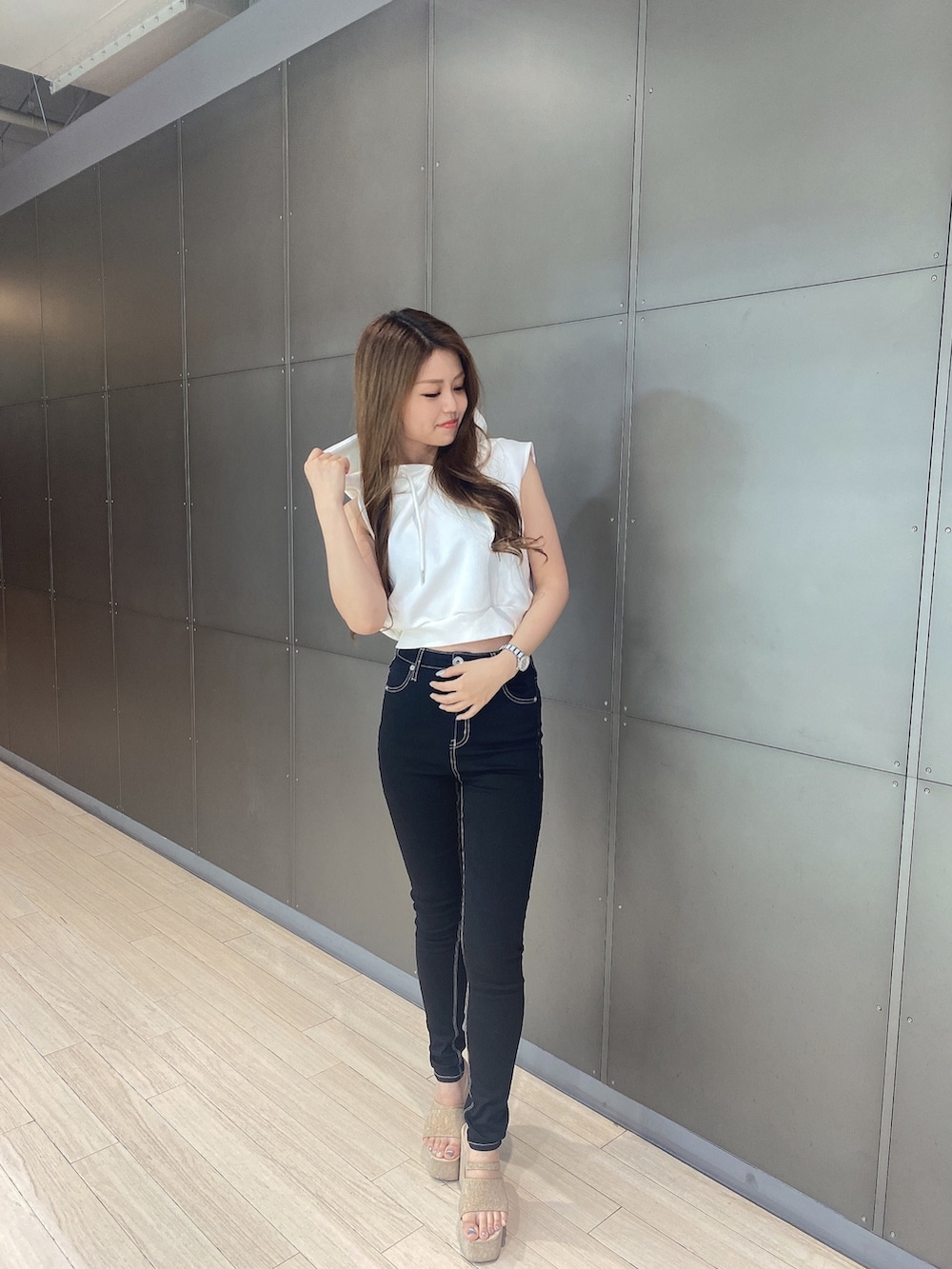 ホワイト系のパーカー、ブラック系のデニムパンツ、ホワイト系のサンダルを着用したレディースの夏コーディネートの2枚目の写真