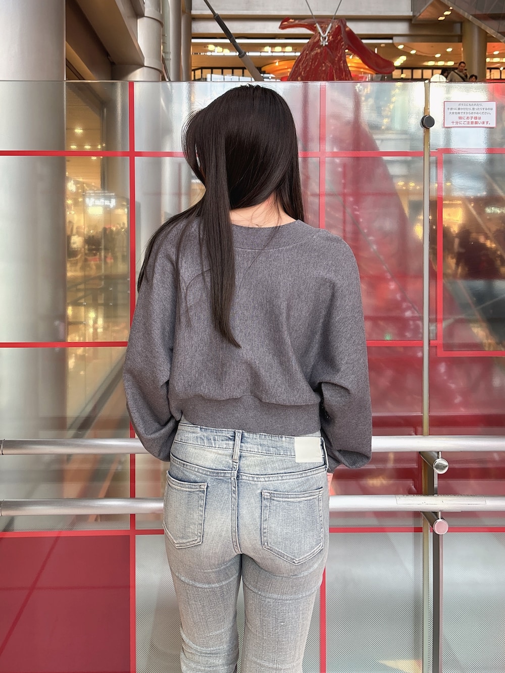 グレー系のニット/セーター、ブルー系のデニムパンツ、ブラック系のブーツを着用したレディースの冬コーディネートの6枚目の写真