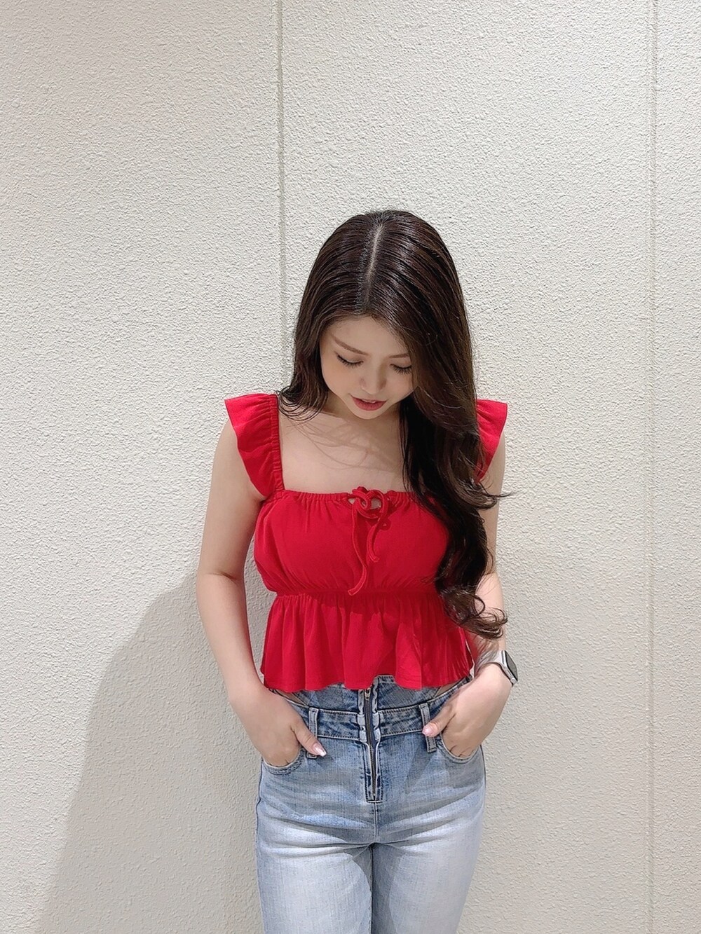 レッド系のTシャツ/カットソー、ブルー系のデニムパンツ、ホワイト系のサンダルを着用したレディースの春コーディネートの6枚目の写真