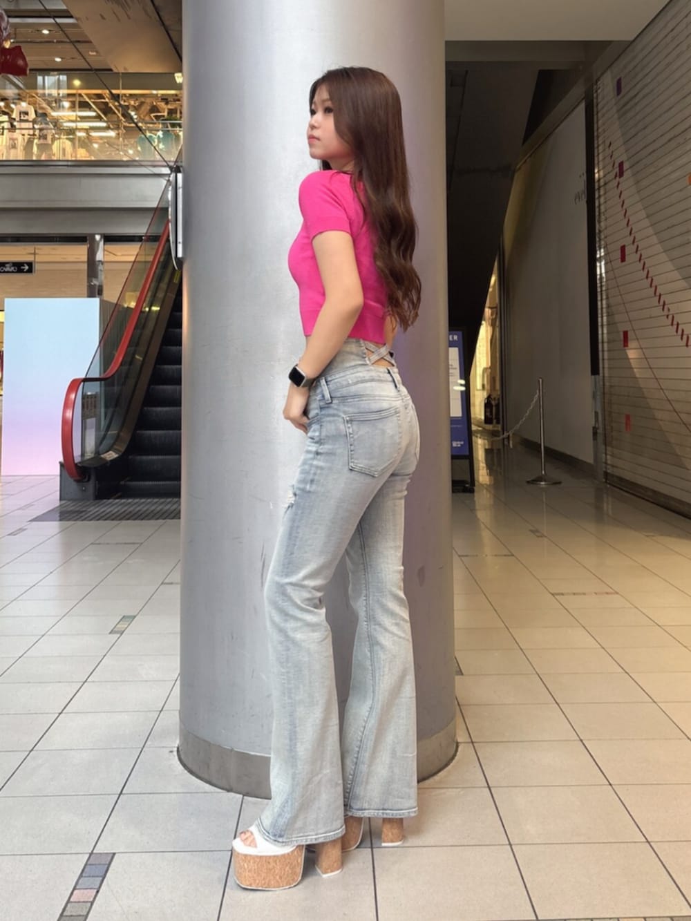 ブルー系のデニムパンツ、ホワイト系のサンダル、ピンク系のニット/セーターを着用したレディースの夏コーディネートの2枚目の写真