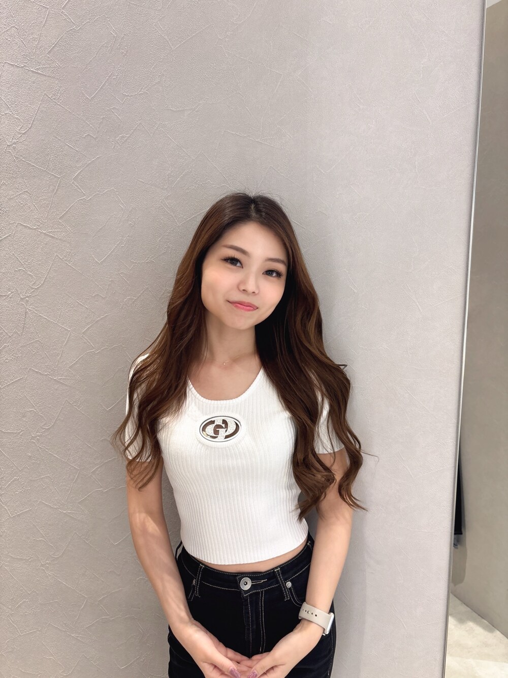 ホワイト系のニット/セーター、ブラック系のデニムパンツ、ホワイト系のサンダルを着用したレディースの夏コーディネートの4枚目の写真