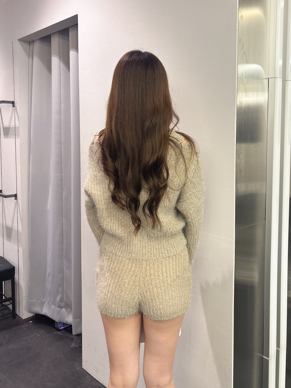 ベージュ系のその他パンツ、ベージュ系のニット/セーター、ホワイト系のハンドバッグを着用したレディースの秋コーディネートの6枚目の写真