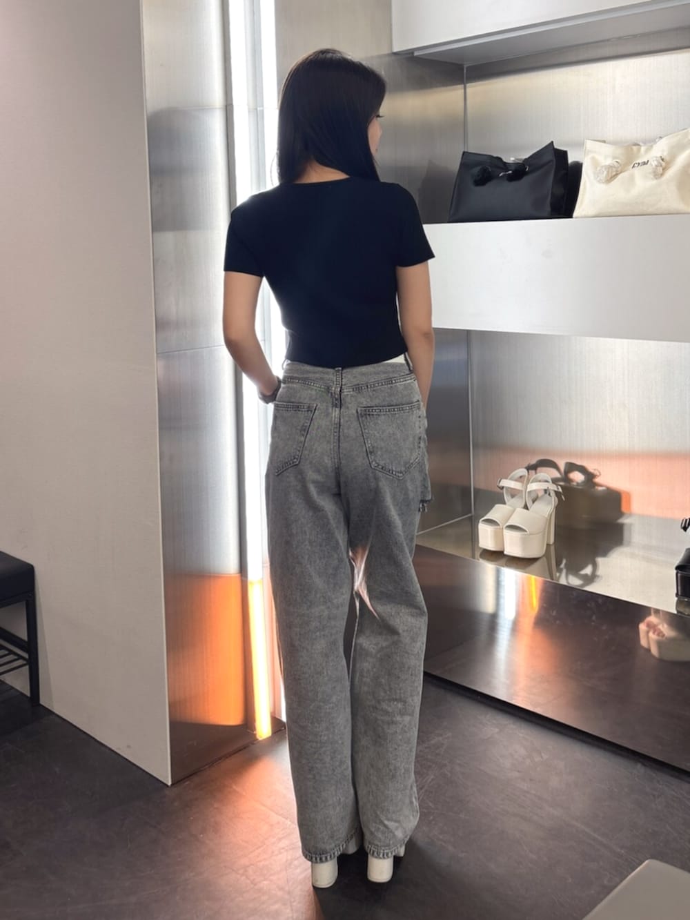 ホワイト系のTシャツ/カットソー、ホワイト系のサンダル、ブルー系のデニムパンツを着用したレディースの春コーディネートの3枚目の写真