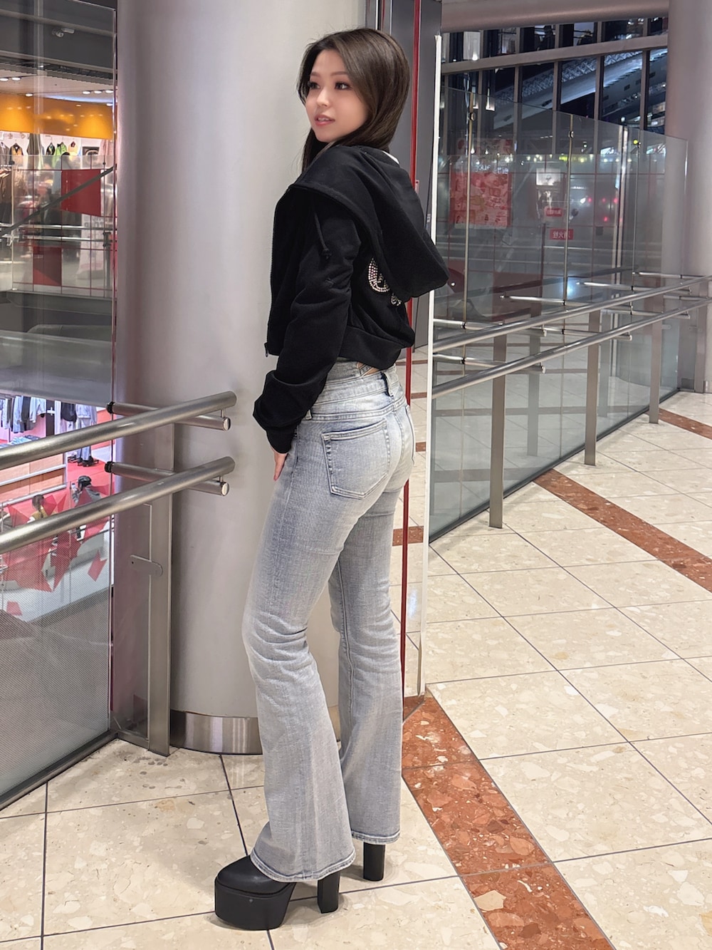 ブラック系のブーツ、ブルー系のデニムパンツ、ブラック系のニット/セーターを着用したレディースの冬コーディネートの2枚目の写真