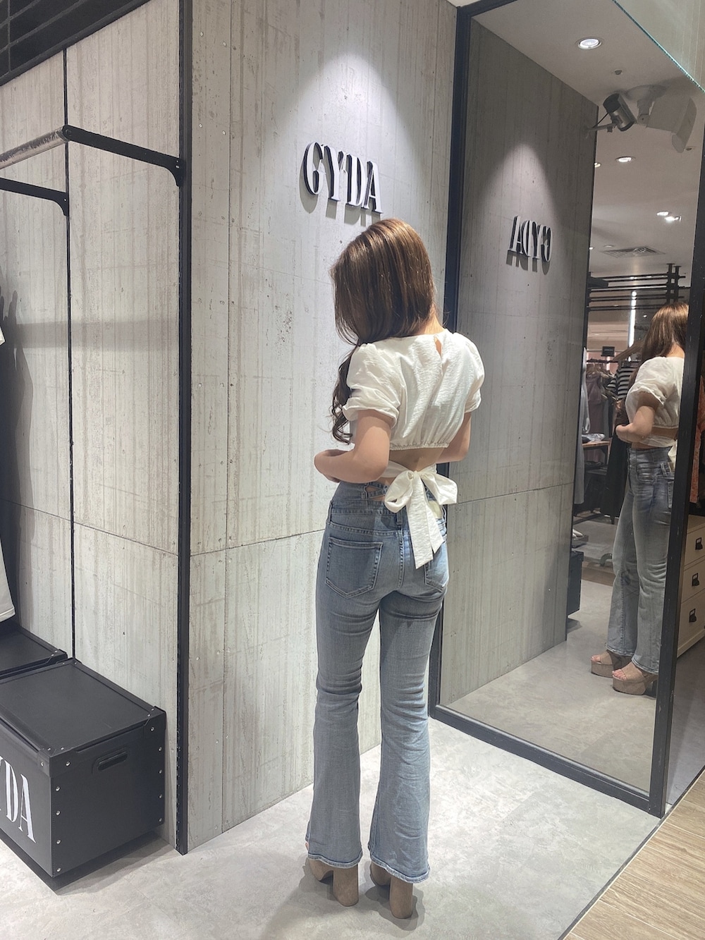 ホワイト系のシャツ/ブラウス、ブルー系のデニムパンツ、ホワイト系のサンダルを着用したレディースの夏コーディネートの2枚目の写真