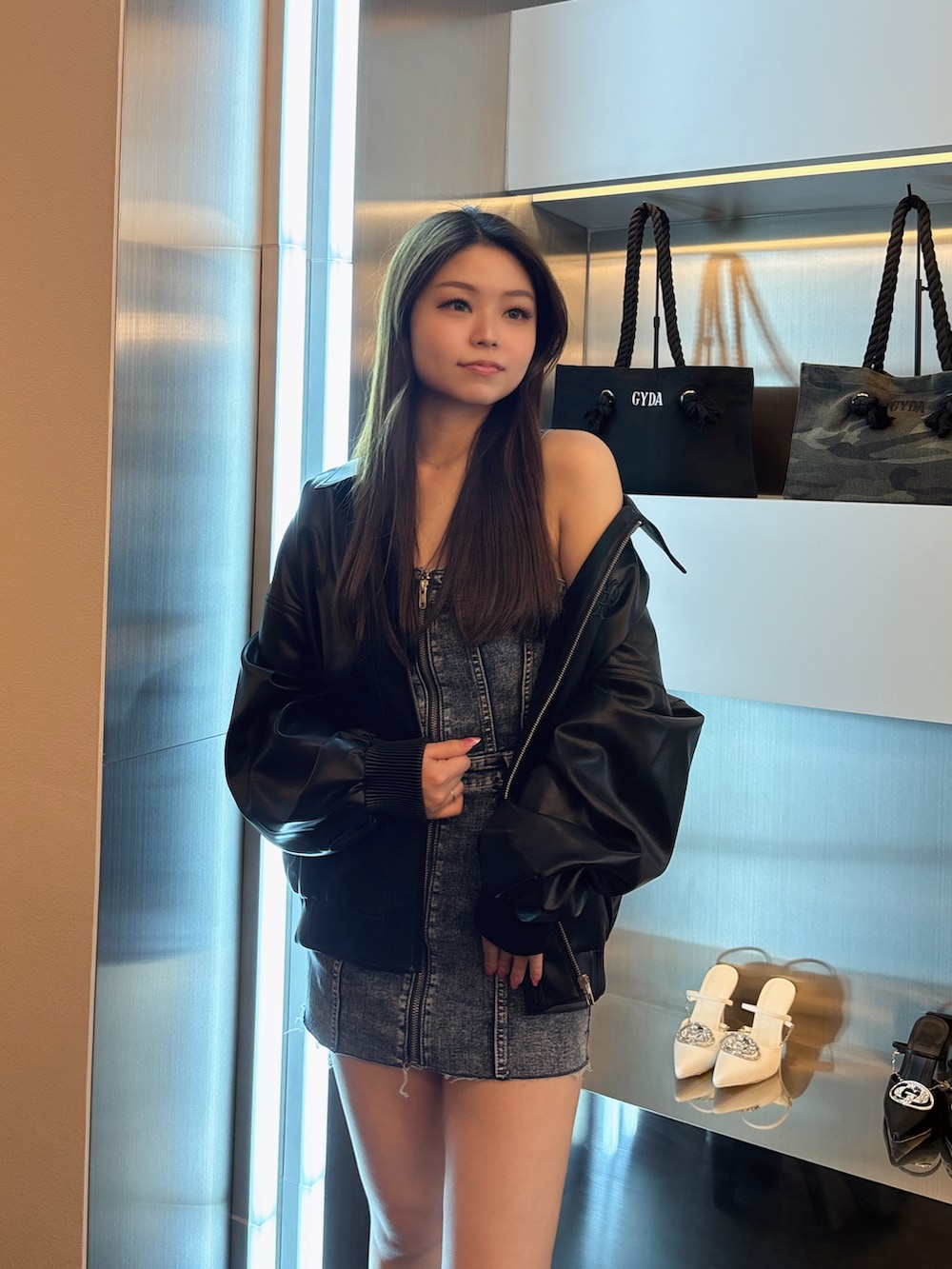 ブルー系のデニムジャケット、ブラック系のブルゾン、ブラック系のブーツを着用したレディースの春コーディネートの4枚目の写真