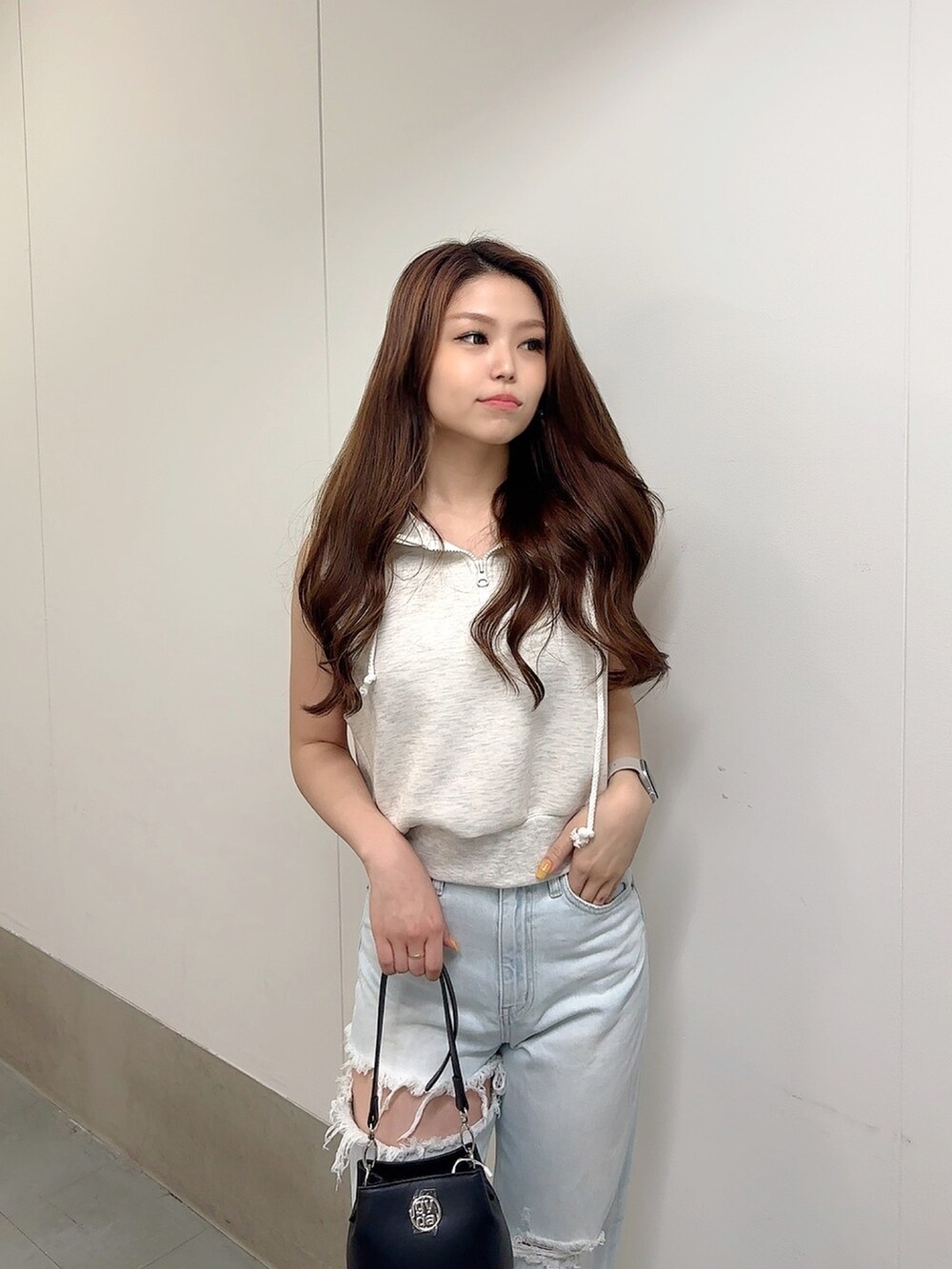 グレー系のTシャツ/カットソー、ブルー系のデニムパンツ、ブラック系のショルダーバッグを着用したレディースの夏コーディネートの6枚目の写真