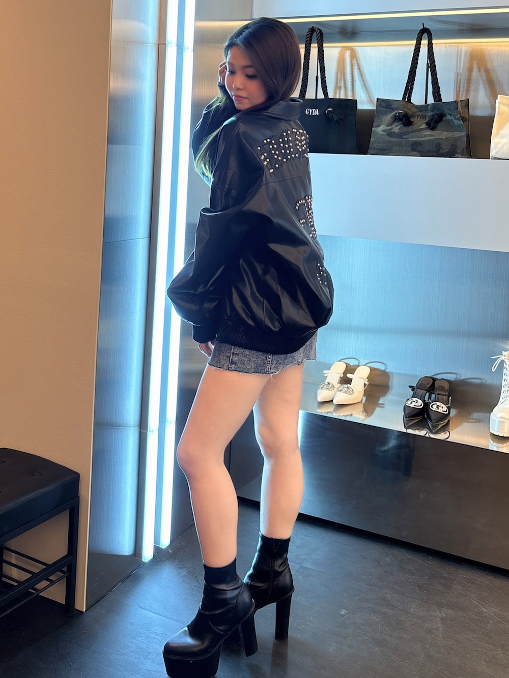 ブルー系のデニムジャケット、ブラック系のブルゾン、ブラック系のブーツを着用したレディースの春コーディネートの2枚目の写真