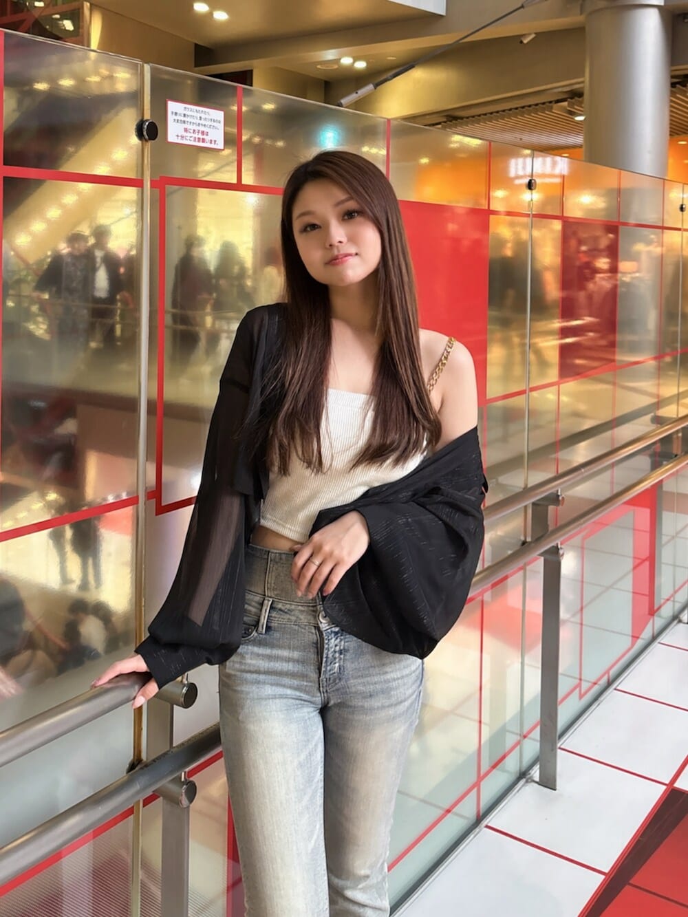 ブラック系のブーツ、ブルー系のデニムパンツ、ホワイト系のキャミソールを着用したレディースの春コーディネートの4枚目の写真