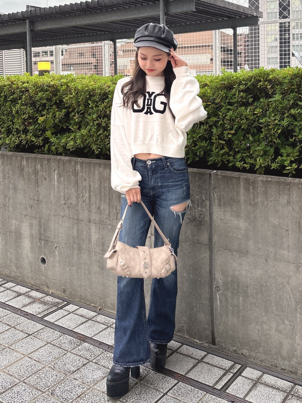 ホワイト系のニット/セーター、ブルー系のデニムパンツ、ベージュ系のショルダーバッグを着用したレディースの秋コーディネートの3枚目の写真