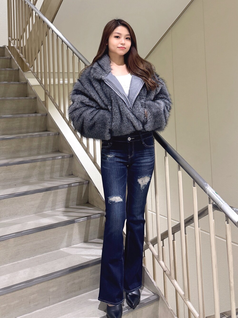 グレー系のその他アウター、ブルー系のデニムパンツ、ブラック系のパンプスを着用したレディースの冬コーディネートの2枚目の写真