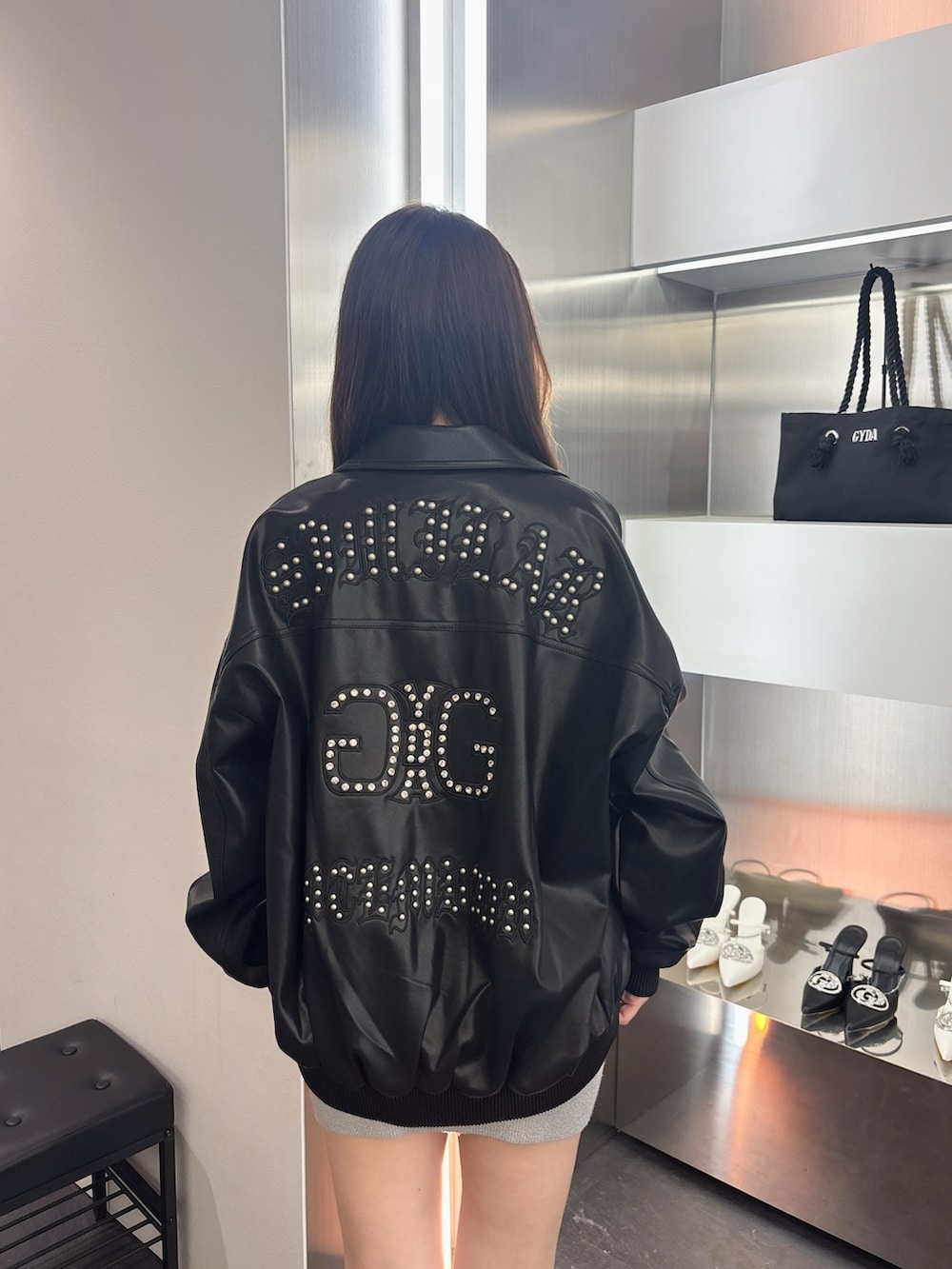 シルバー系のワンピース、ブラック系のブーツ、ブラック系のブルゾンを着用したレディースの春コーディネートの6枚目の写真