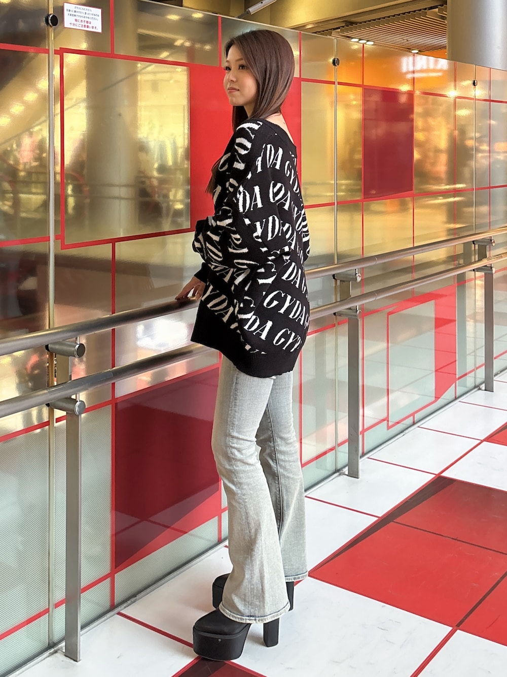 ブラック系のカーディガン/ボレロ、ホワイト系のキャミソール、ブルー系のデニムパンツを着用したレディースの春コーディネートの2枚目の写真