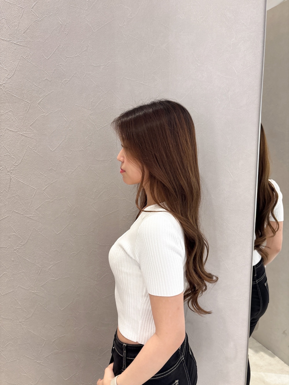 ホワイト系のニット/セーター、ブラック系のデニムパンツ、ホワイト系のサンダルを着用したレディースの夏コーディネートの5枚目の写真