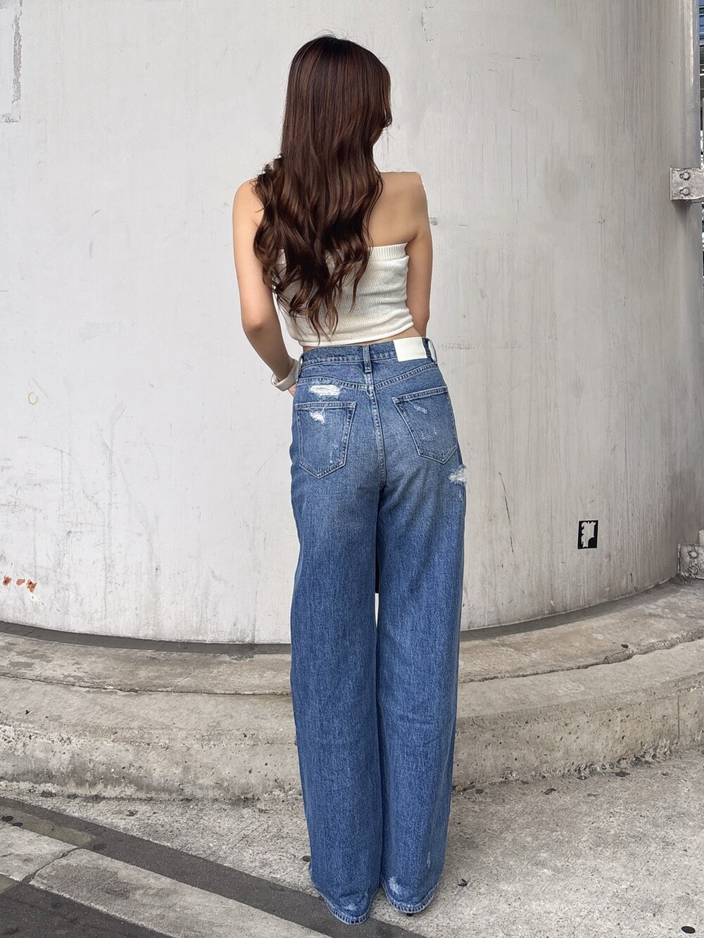 ホワイト系のニット/セーター、ブルー系のデニムパンツ、ホワイト系のパンプスを着用したレディースの夏コーディネートの3枚目の写真