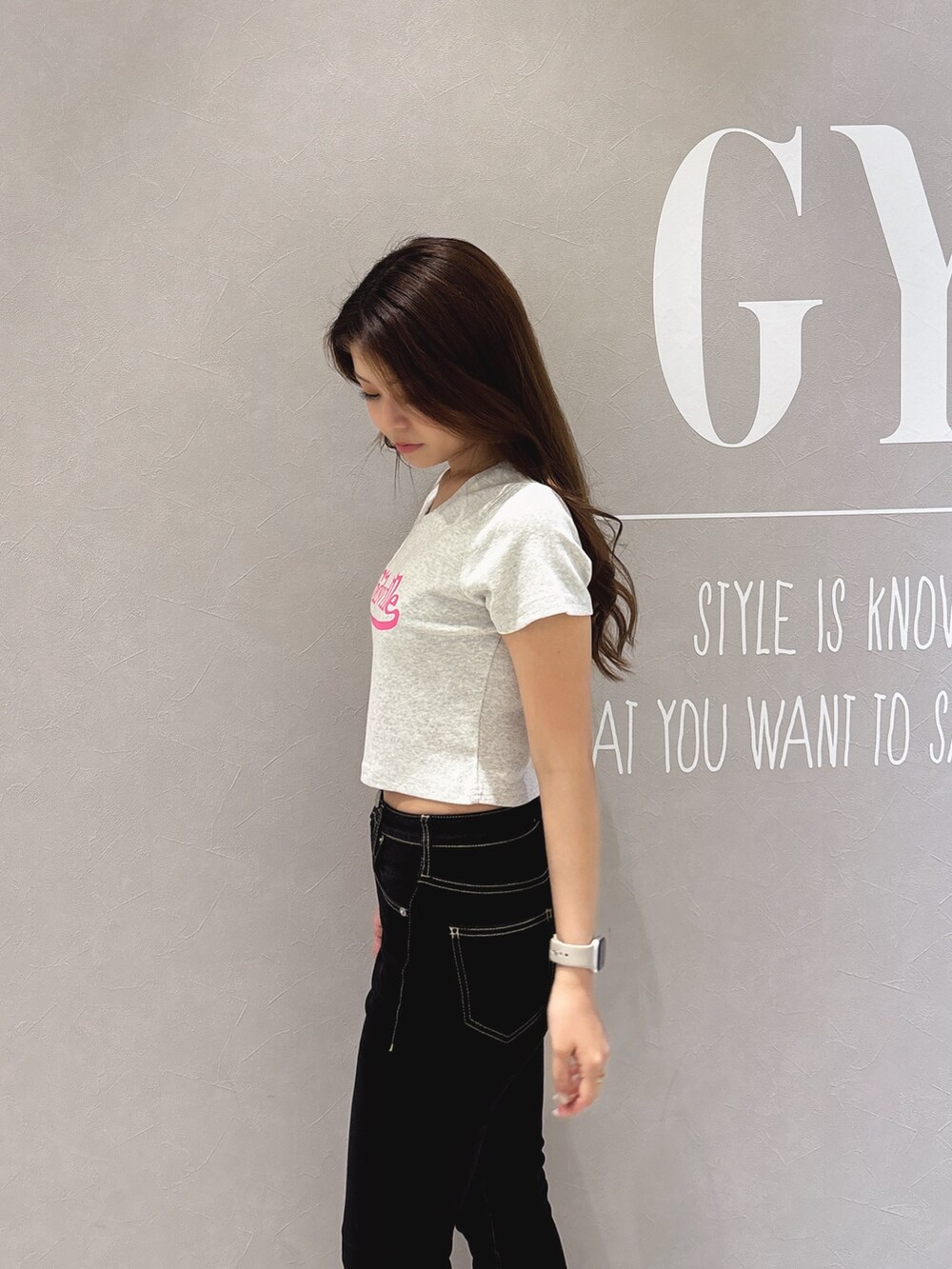 グレー系のTシャツ/カットソー、ブラック系のデニムパンツ、ホワイト系のパンプスを着用したレディースの春コーディネートの6枚目の写真