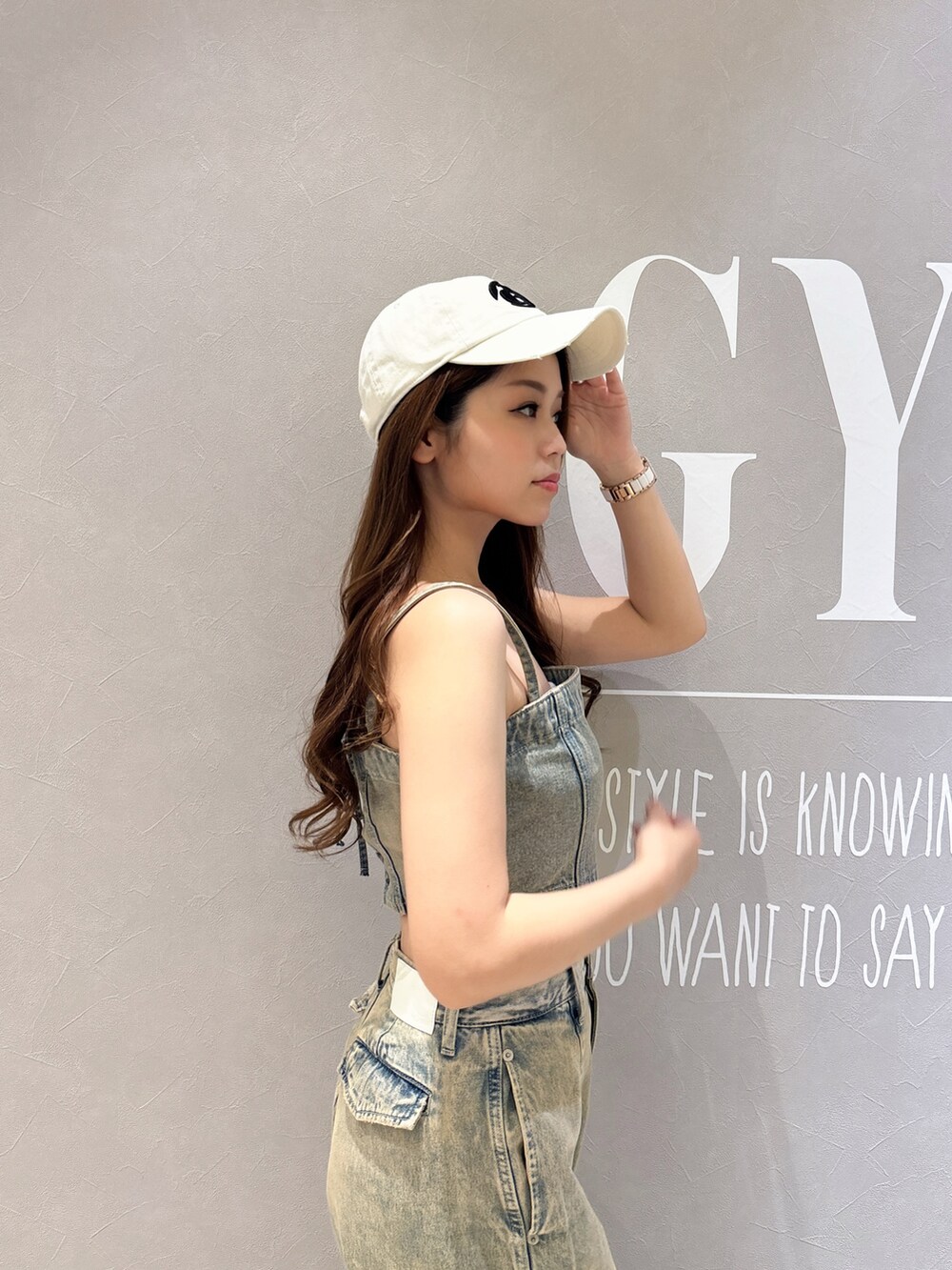 ブルー系のキャミソール、ブルー系のデニムパンツ、ブラック系のサンダルを着用したレディースの夏コーディネートの5枚目の写真