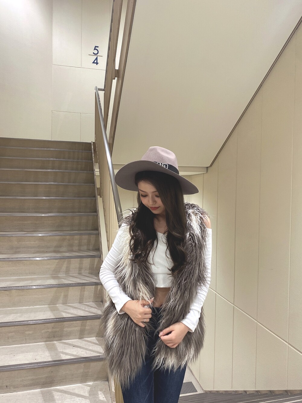 ホワイト系のTシャツ/カットソー、その他のベスト、ブルー系のデニムパンツを着用したレディースの秋コーディネートの5枚目の写真