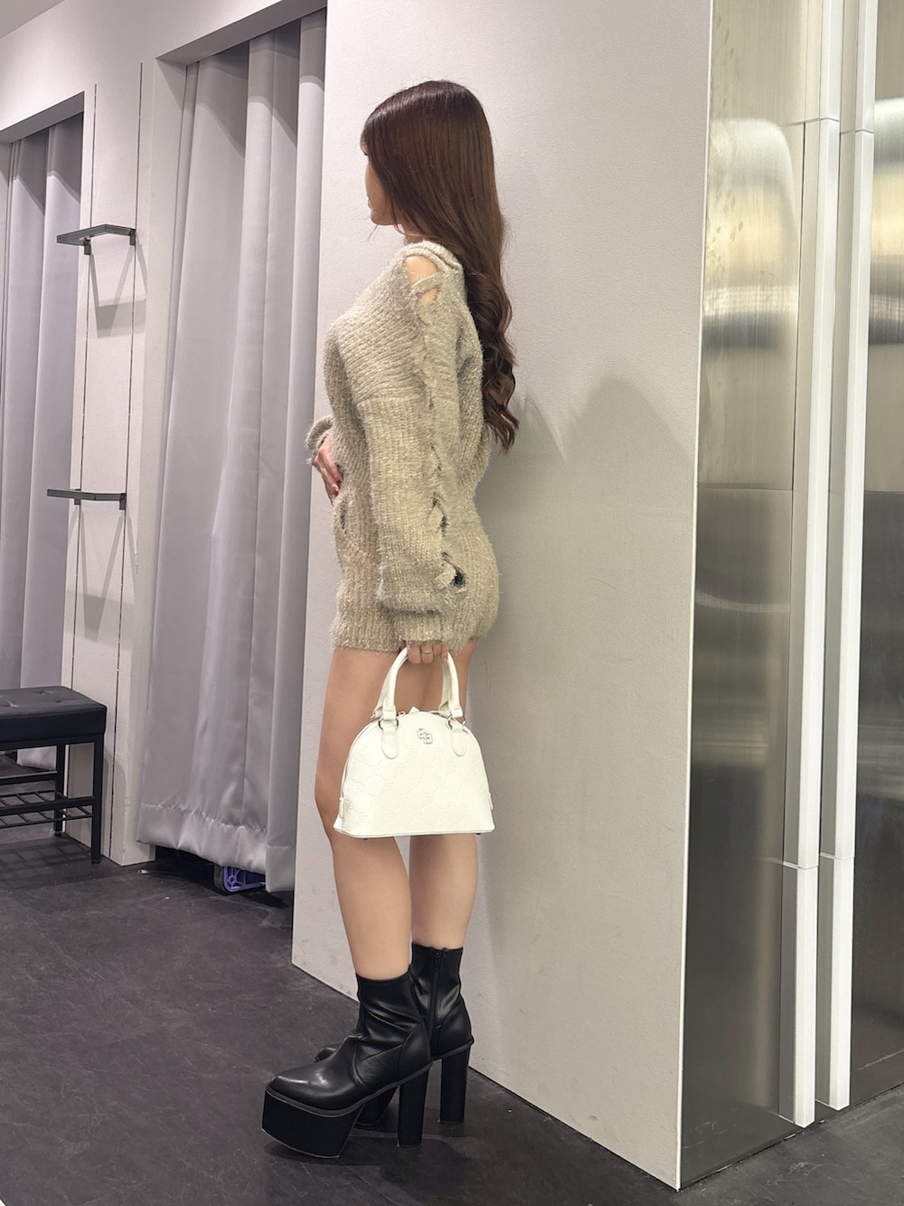 ベージュ系のその他パンツ、ベージュ系のニット/セーター、ホワイト系のハンドバッグを着用したレディースの秋コーディネートの2枚目の写真