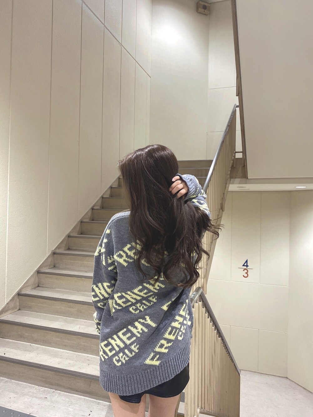 グレー系のニット/セーター、ブラック系のブーツを着用したレディースの秋コーディネートの5枚目の写真