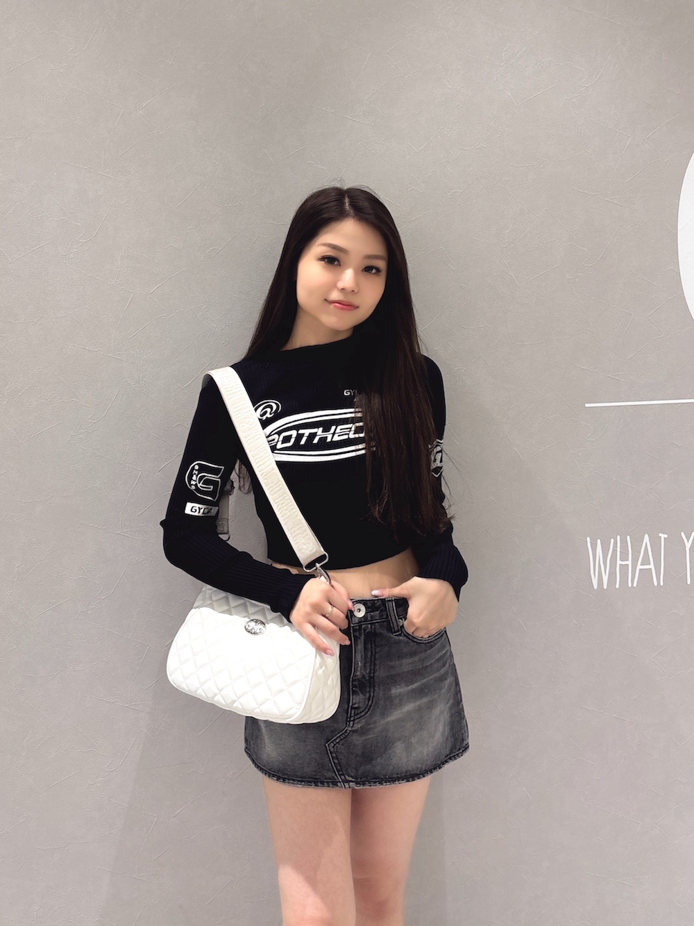 ブラック系のニット/セーター、ブラック系のデニムスカート、ブラック系のブーツを着用したレディースの秋コーディネートの6枚目の写真