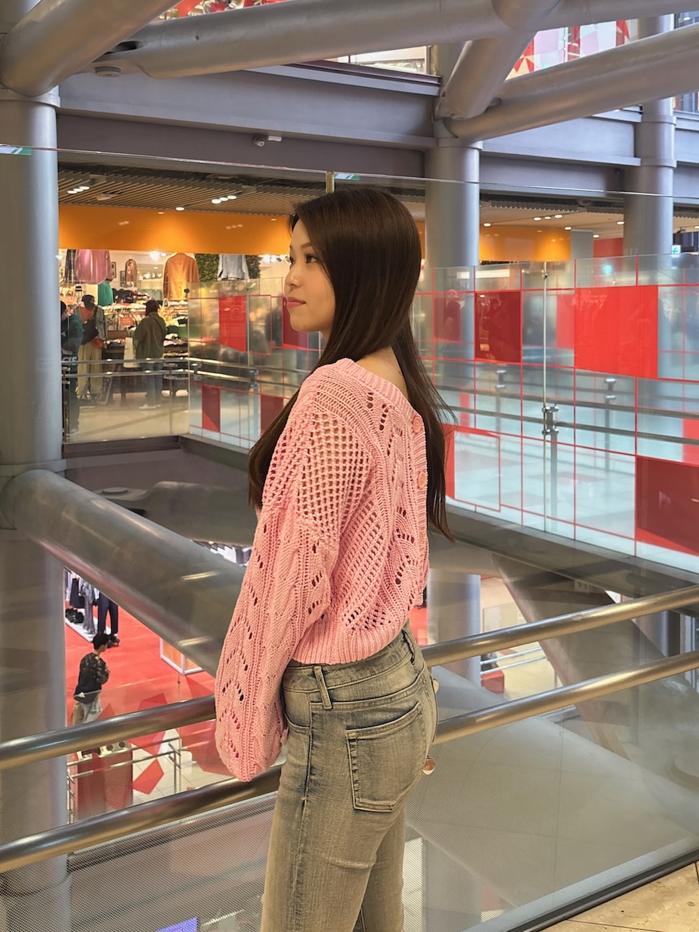 ピンク系のニット/セーター、ホワイト系のキャミソール、ブルー系のデニムパンツを着用したレディースの春コーディネートの5枚目の写真