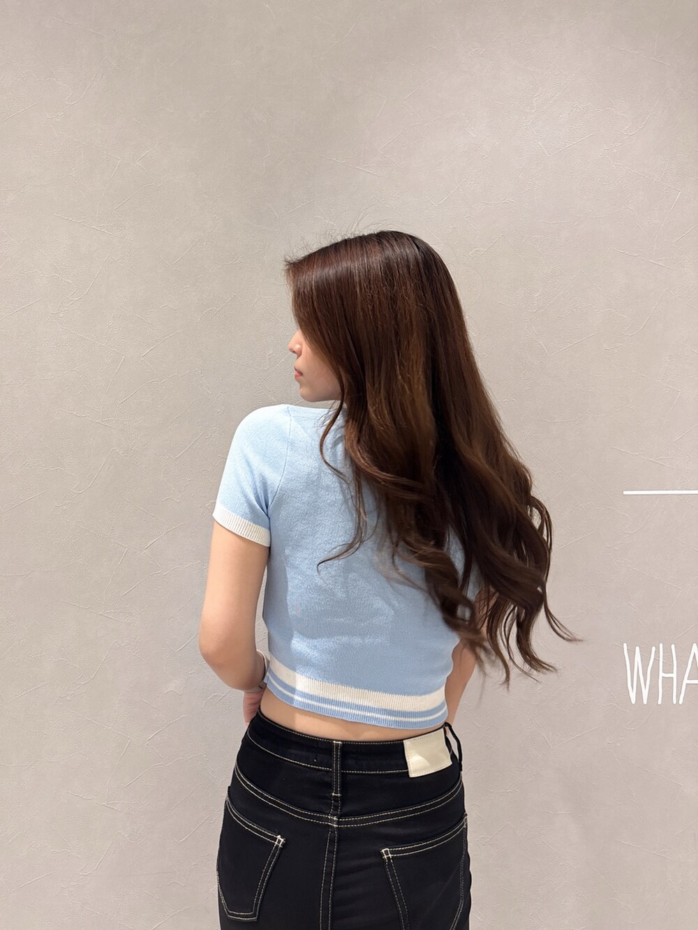 ブルー系のニット/セーター、ブラック系のデニムパンツ、ホワイト系のパンプスを着用したレディースの春コーディネートの6枚目の写真