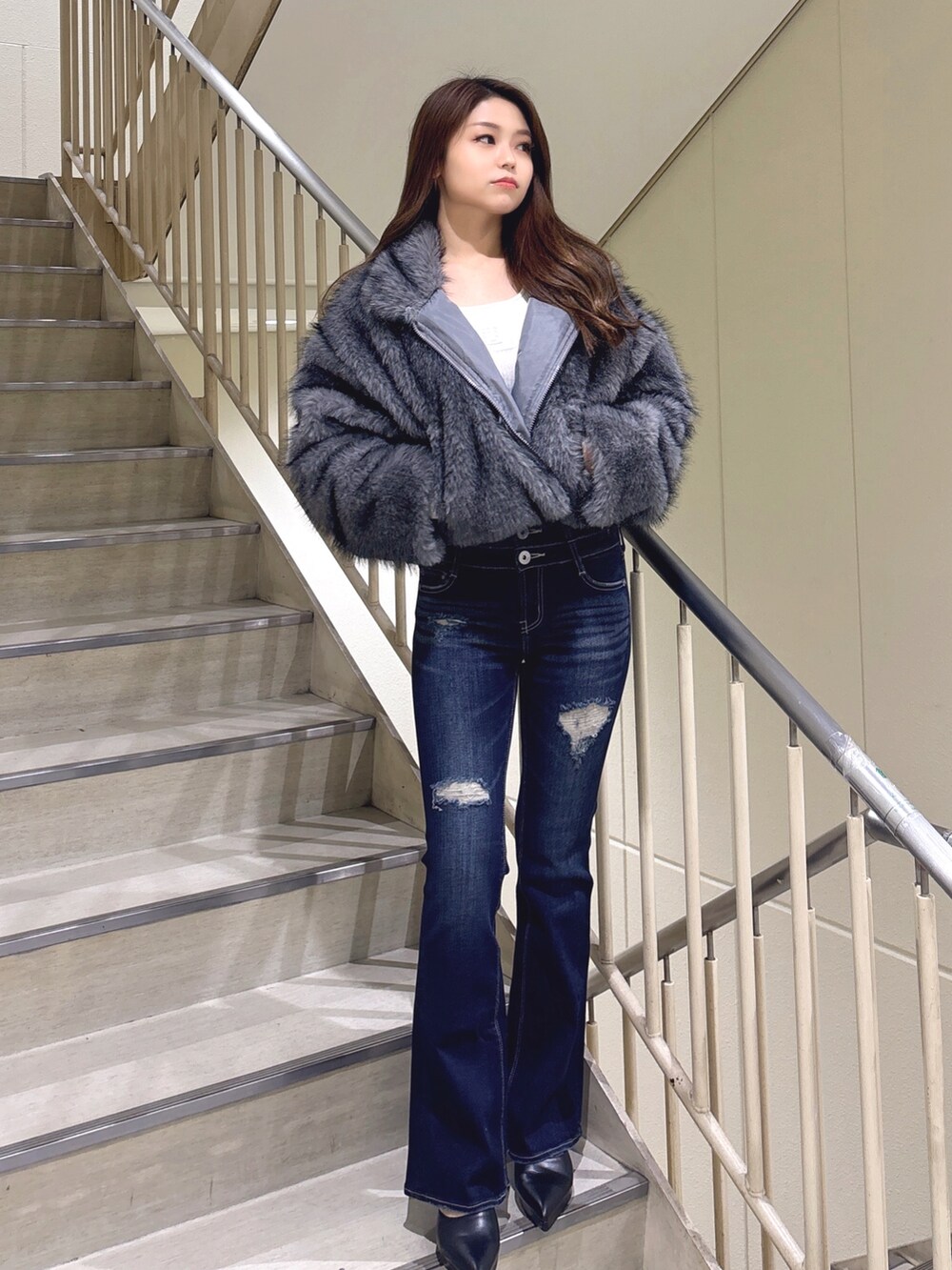 グレー系のその他アウター、ブルー系のデニムパンツ、ブラック系のパンプスを着用したレディースの冬コーディネートの3枚目の写真