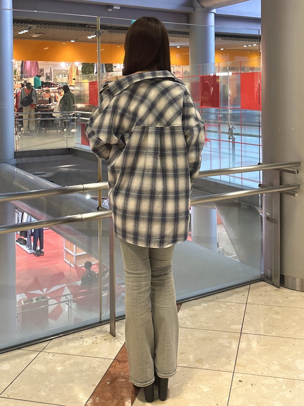 ホワイト系のキャミソール、ブルー系のデニムパンツ、ブラック系のブーツを着用したレディースの春コーディネートの3枚目の写真