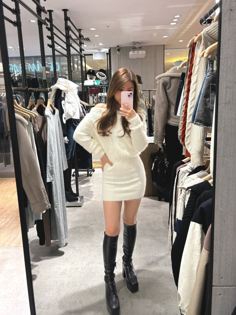 ホワイト系のワンピース、ブラック系のブーツを着用したレディースの秋コーディネートの2枚目の写真