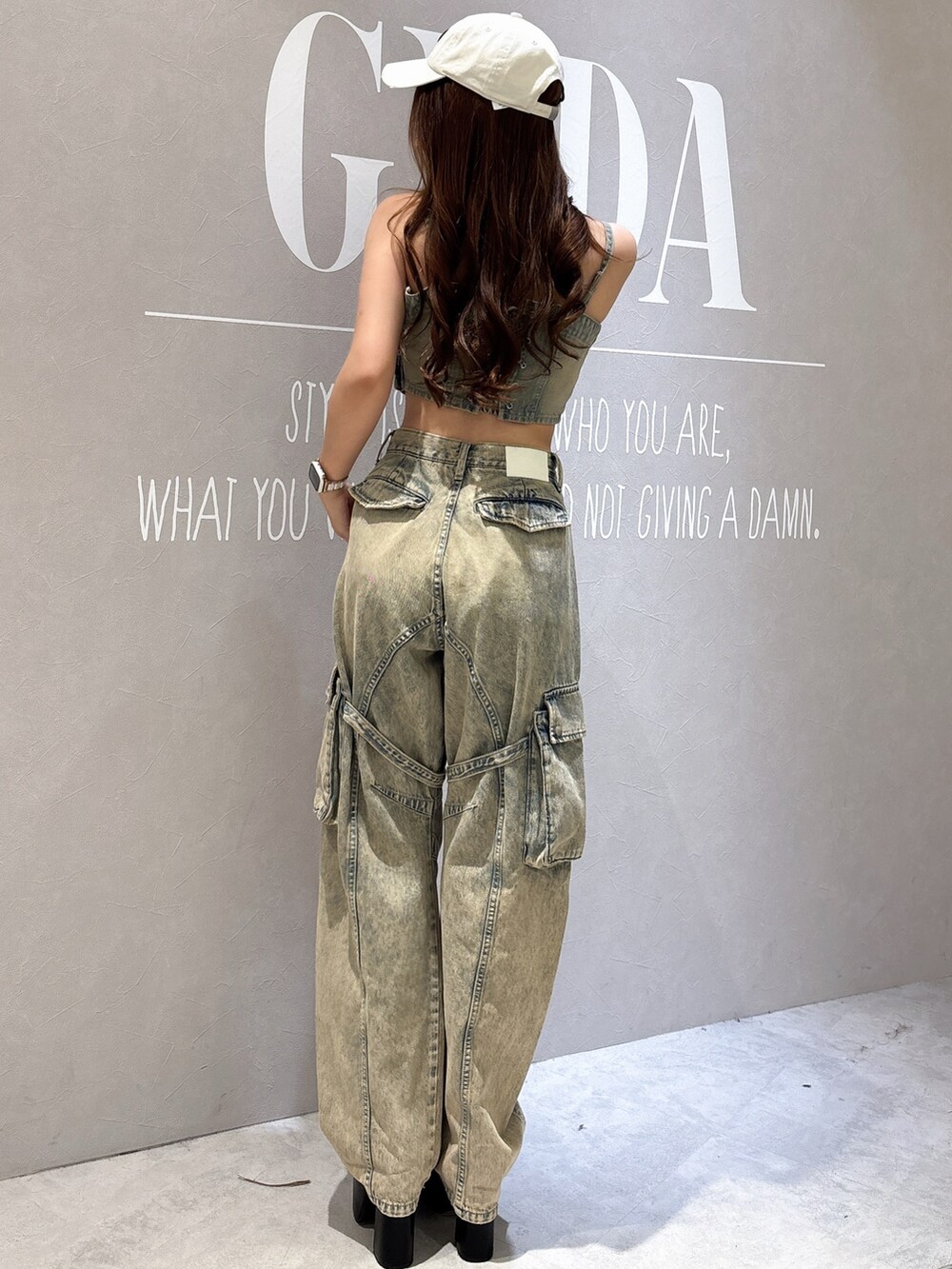 ブルー系のキャミソール、ブルー系のデニムパンツ、ブラック系のサンダルを着用したレディースの夏コーディネートの3枚目の写真