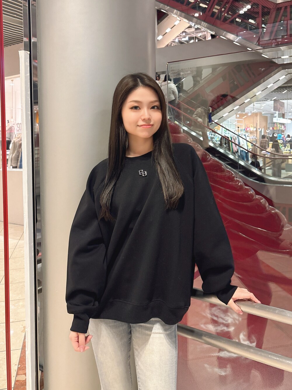 ブラック系のスウェット、ブルー系のデニムパンツ、ブラック系のブーツを着用したレディースの冬コーディネートの4枚目の写真