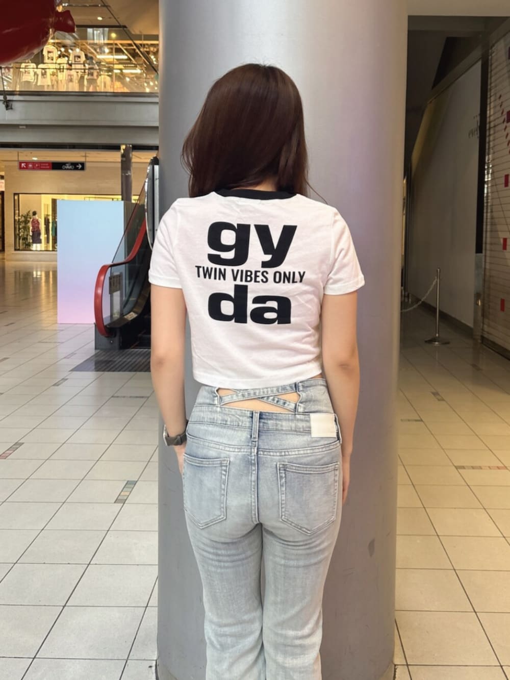 ブルー系のデニムパンツ、ホワイト系のサンダル、ホワイト系のTシャツ/カットソーを着用したレディースの夏コーディネートの6枚目の写真