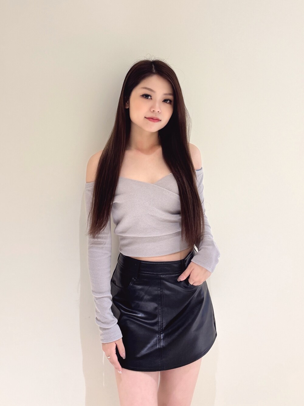 グレー系のTシャツ/カットソー、ブラック系のスカート、ブラック系のブーツを着用したレディースの秋コーディネートの5枚目の写真