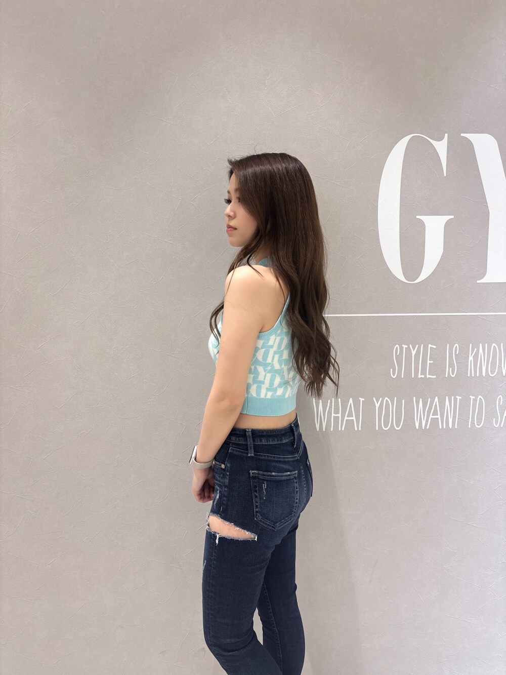 グリーン系のニット/セーター、ブルー系のデニムパンツ、ホワイト系のサンダルを着用したレディースの春コーディネートの6枚目の写真