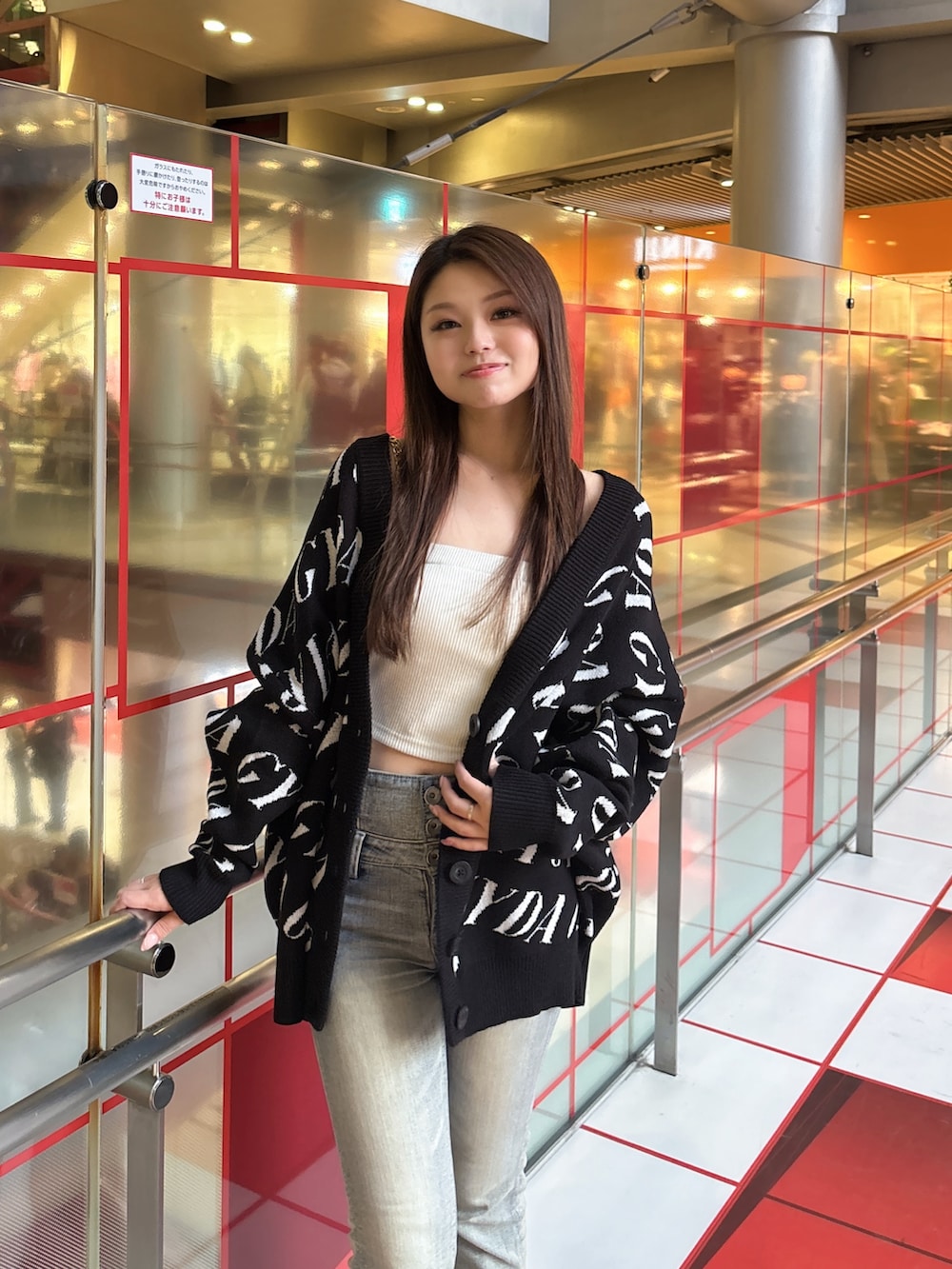 ブラック系のカーディガン/ボレロ、ホワイト系のキャミソール、ブルー系のデニムパンツを着用したレディースの春コーディネートの4枚目の写真