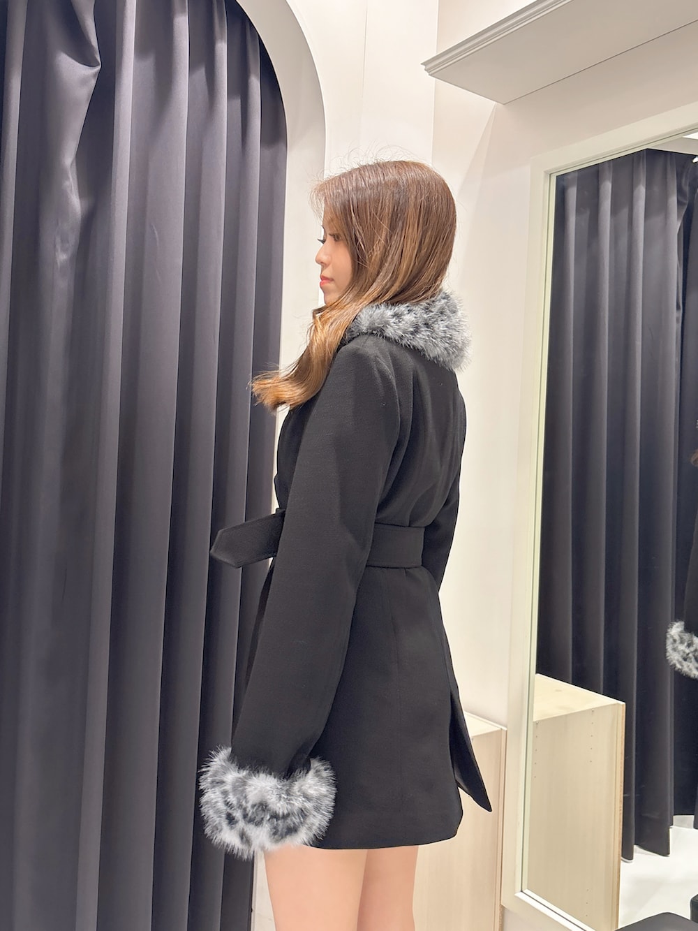 ブラック系のブーツ、ブラック系のチェスターコートを着用したレディースの秋コーディネートの5枚目の写真