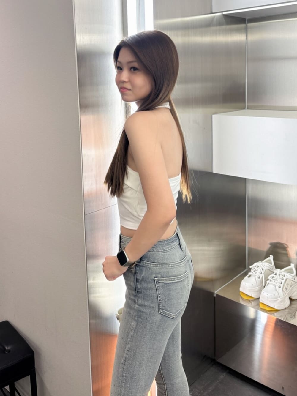 ホワイト系のサンダル、ホワイト系のハンドバッグ、ブルー系のデニムパンツを着用したレディースの夏コーディネートの5枚目の写真