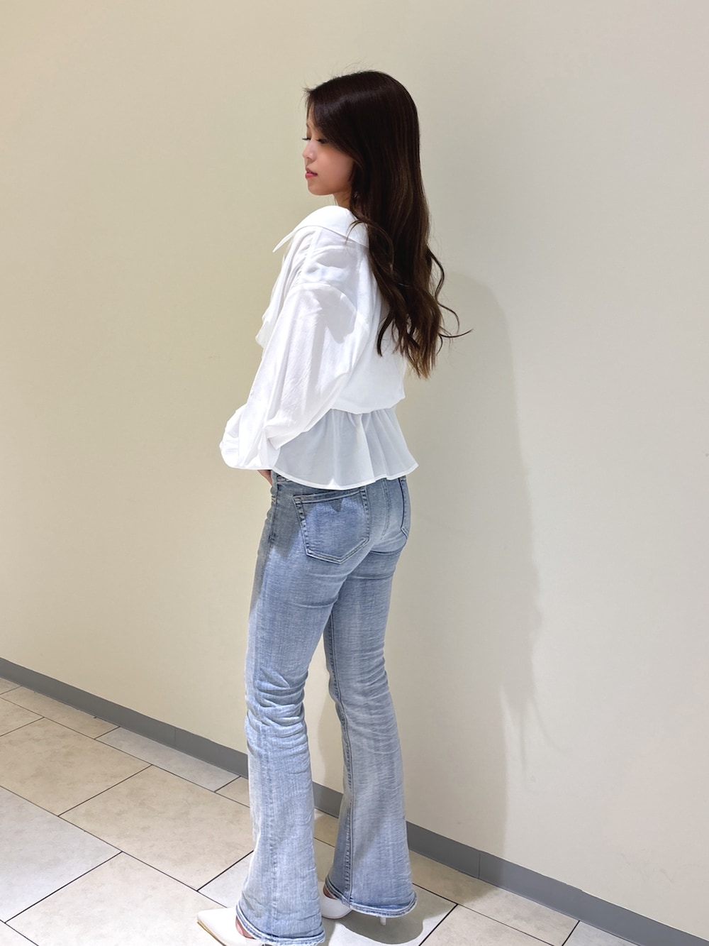 ホワイト系のシャツ/ブラウス、ブルー系のデニムパンツ、ホワイト系のパンプスを着用したレディースの冬コーディネートの4枚目の写真