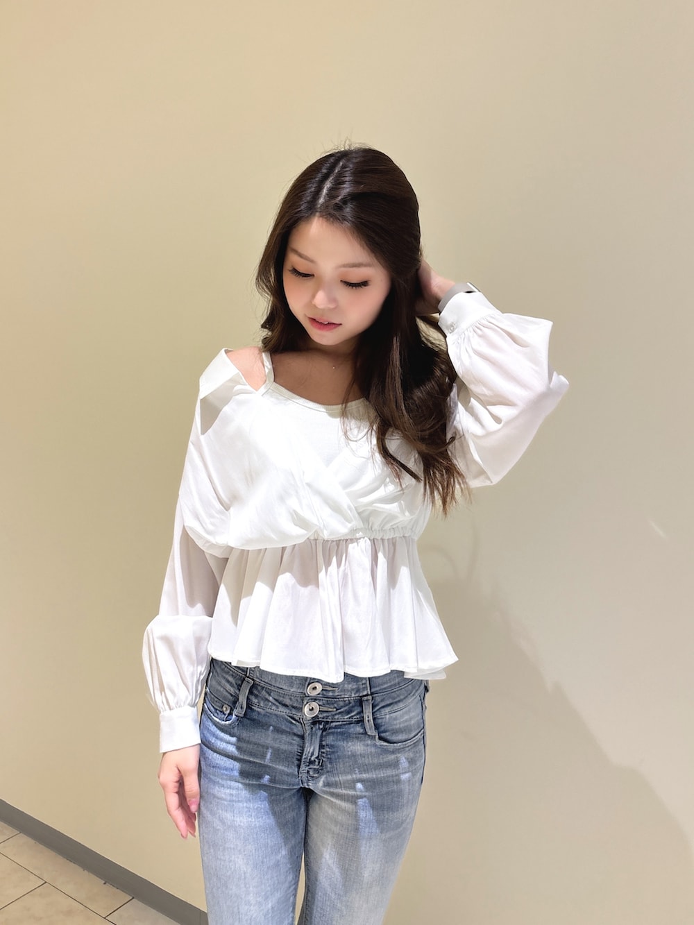 ホワイト系のシャツ/ブラウス、ブルー系のデニムパンツ、ホワイト系のパンプスを着用したレディースの冬コーディネートの7枚目の写真