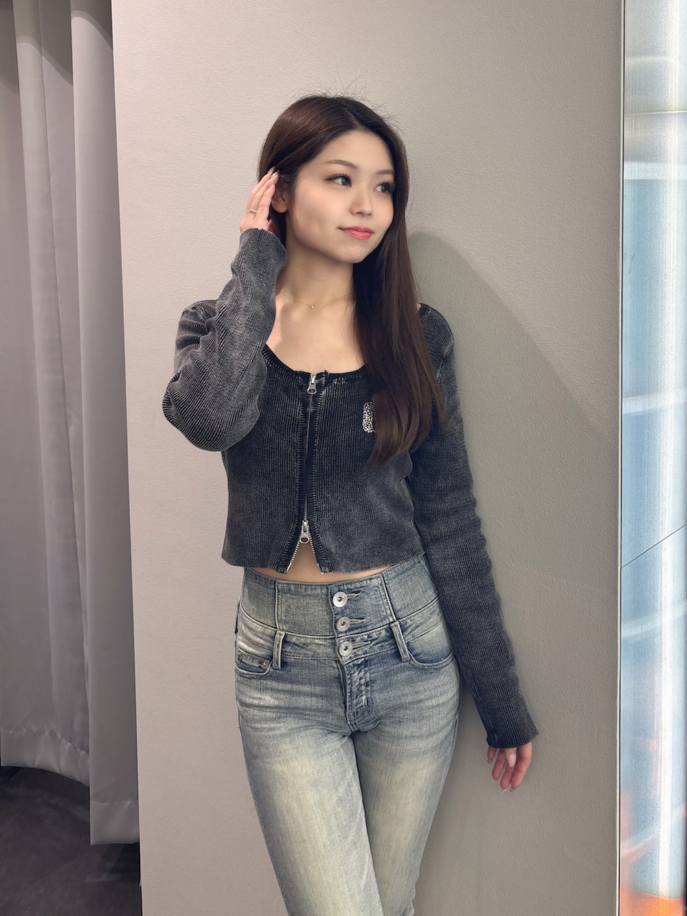 ブラック系のニット/セーター、ブルー系のデニムパンツ、ブラック系のブーツを着用したレディースの春コーディネートの4枚目の写真