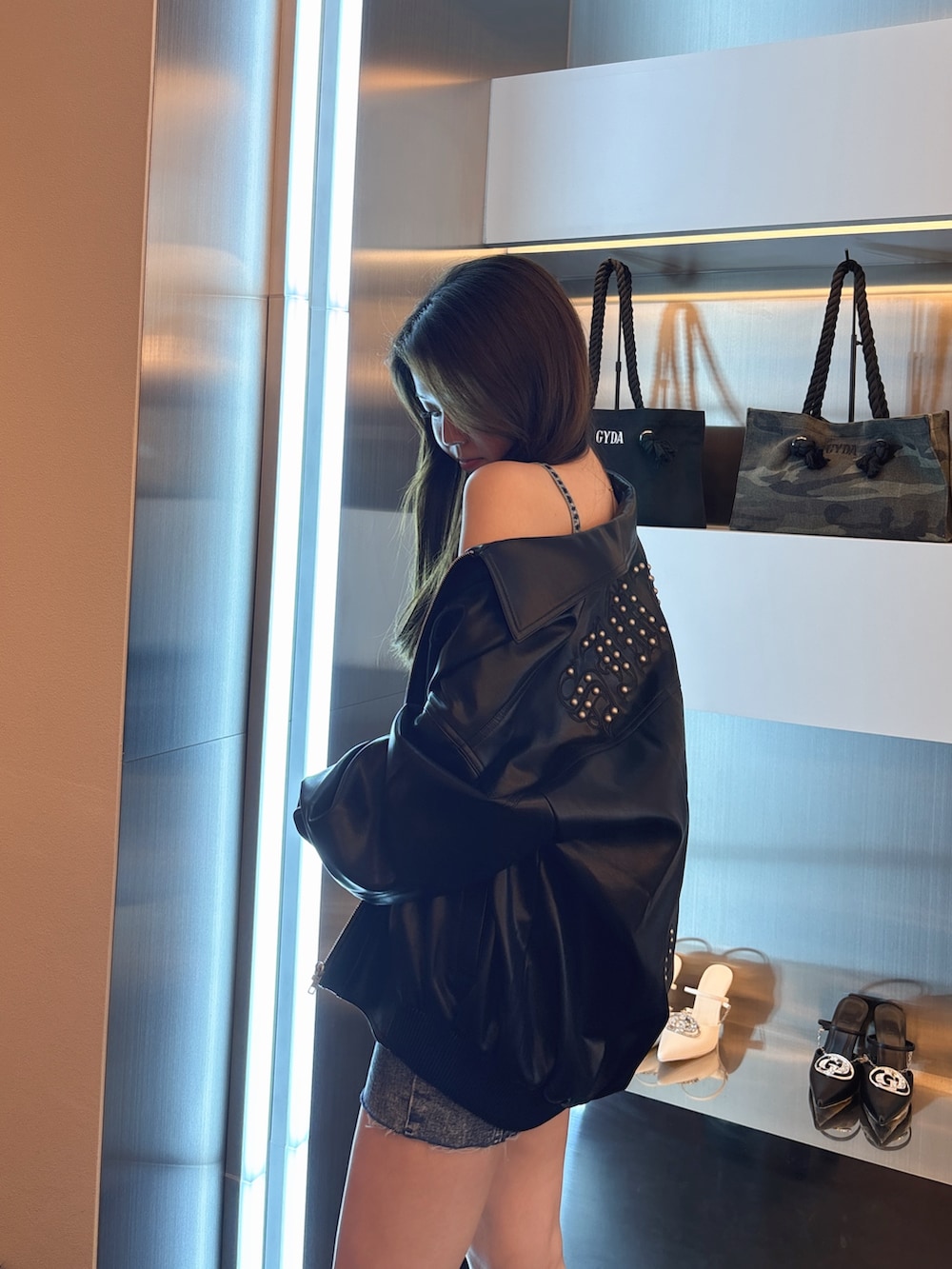 ブルー系のデニムジャケット、ブラック系のブルゾン、ブラック系のブーツを着用したレディースの春コーディネートの5枚目の写真