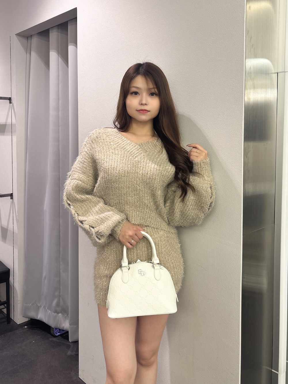 ベージュ系のその他パンツ、ベージュ系のニット/セーター、ホワイト系のハンドバッグを着用したレディースの秋コーディネートの4枚目の写真