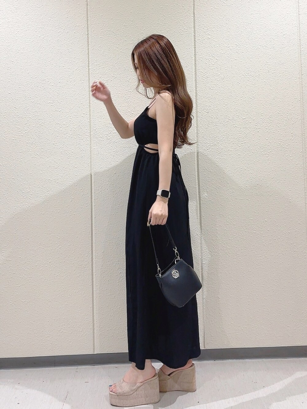 ブラック系のワンピース、ブラック系のショルダーバッグ、ホワイト系のサンダルを着用したレディースの夏コーディネートの3枚目の写真