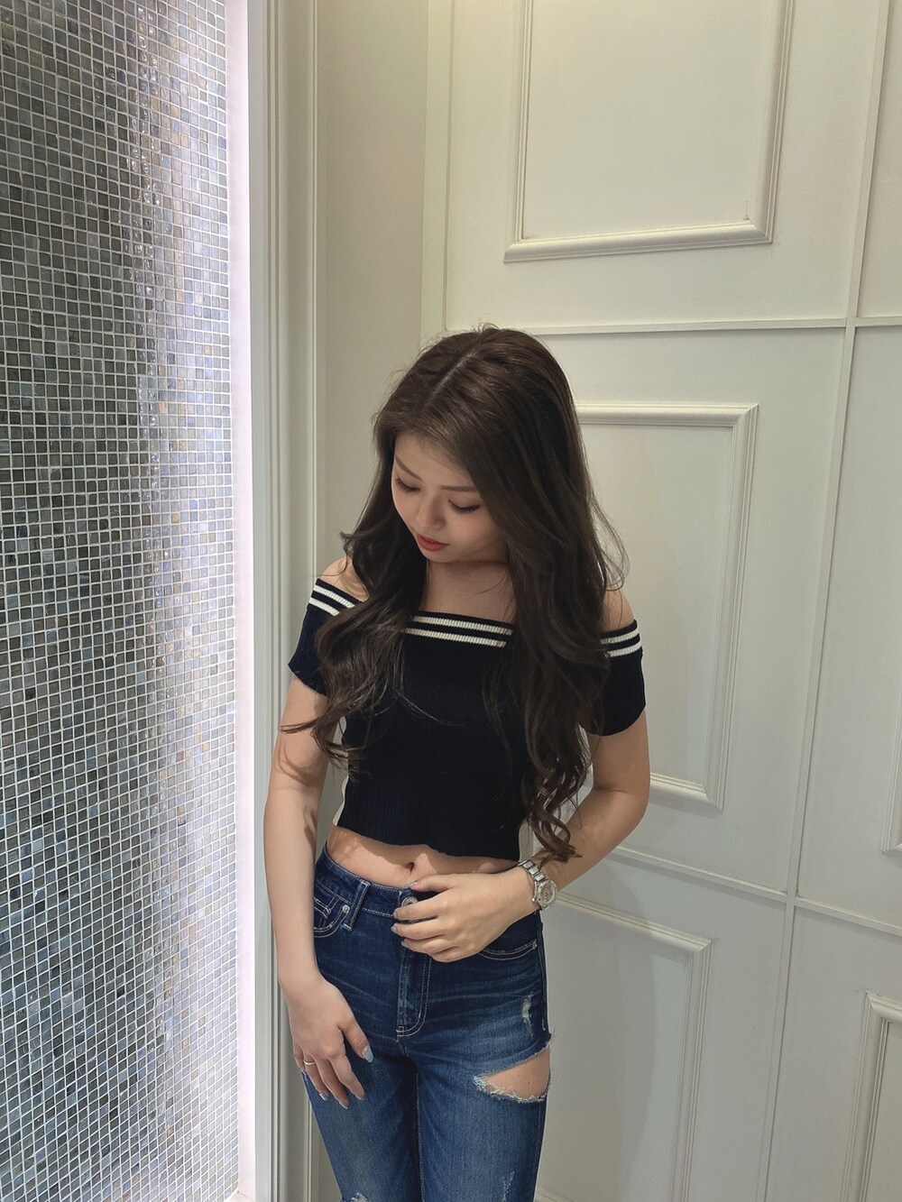 ブラック系のニット/セーター、ブルー系のデニムパンツ、ブラック系のパンプスを着用したレディースの夏コーディネートの4枚目の写真