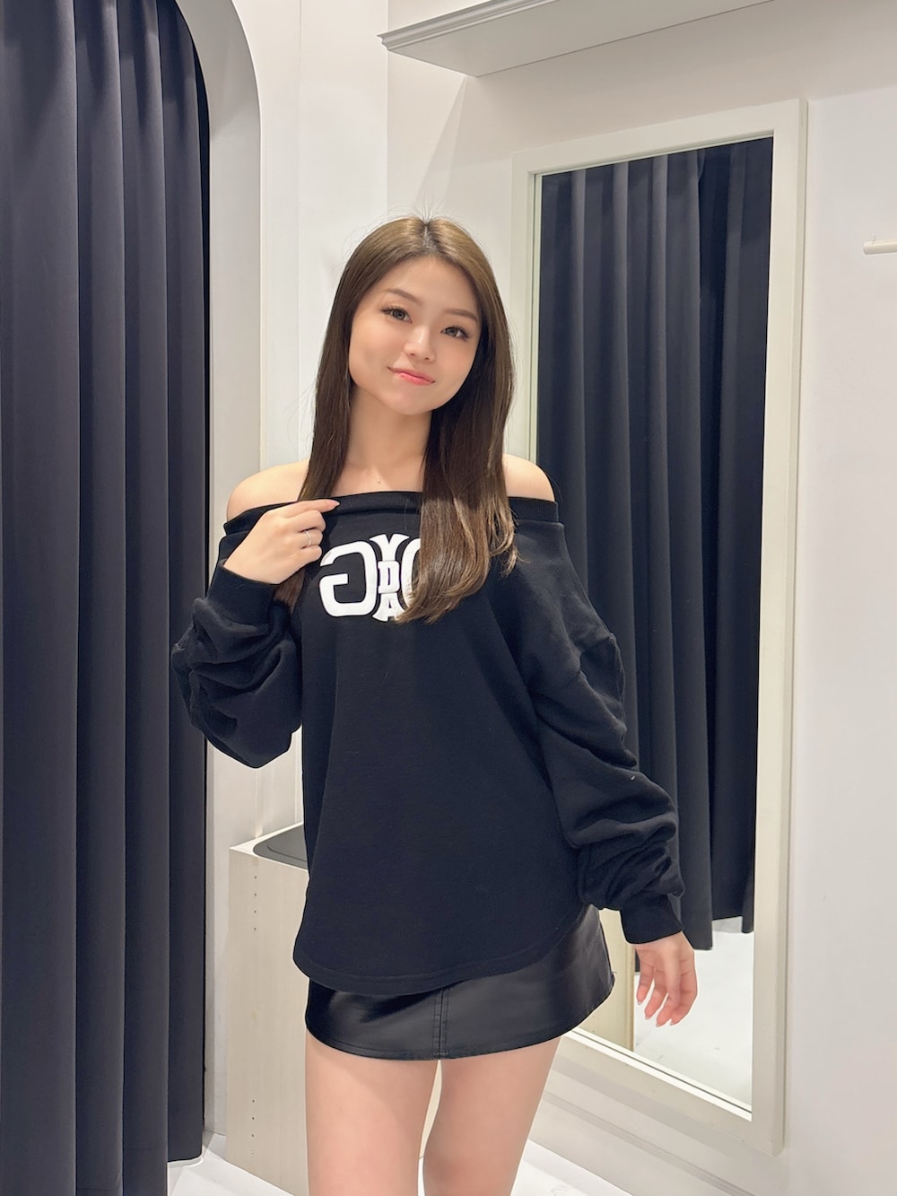 ブラック系のスウェット、ブラック系のスカート、ブラック系のブーツを着用したレディースの秋コーディネートの4枚目の写真