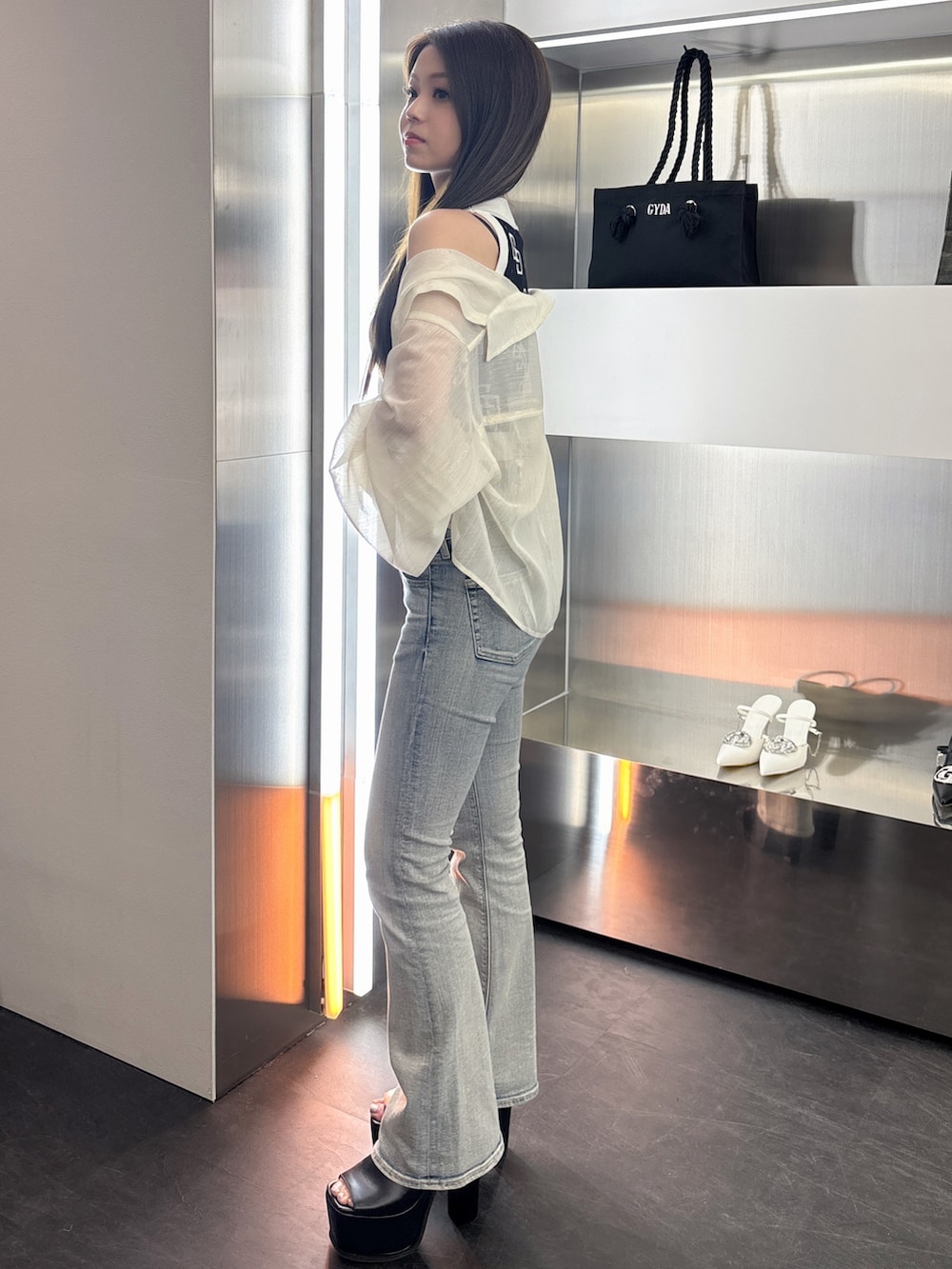 ブルー系のデニムパンツ、ブラック系のサンダル、ブラック系のタンクトップを着用したレディースの春コーディネートの2枚目の写真