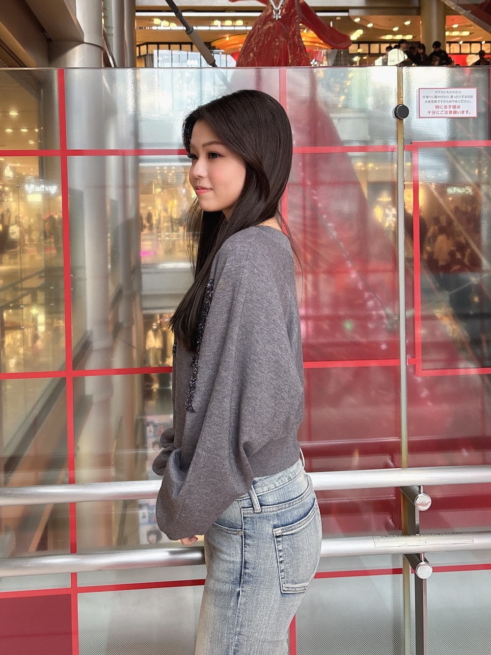 グレー系のニット/セーター、ブルー系のデニムパンツ、ブラック系のブーツを着用したレディースの冬コーディネートの5枚目の写真